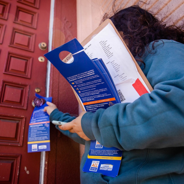 a volunteer putting on a door hanger on a door knob